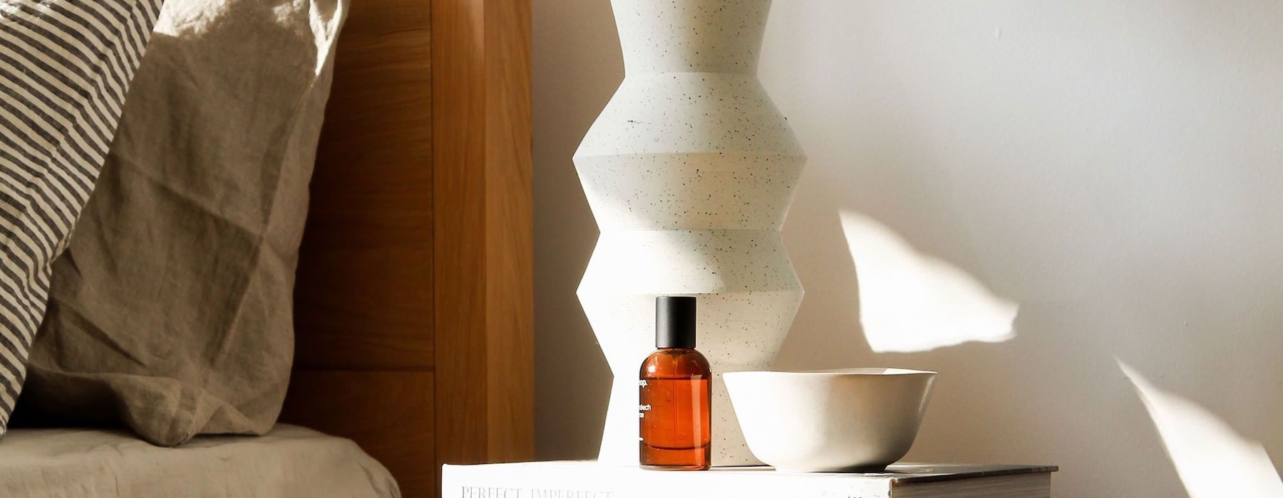 a bed with a nightstand and a lamp